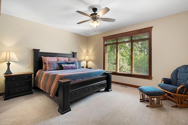 bedroom with a ceiling fan, light carpet, and baseboards