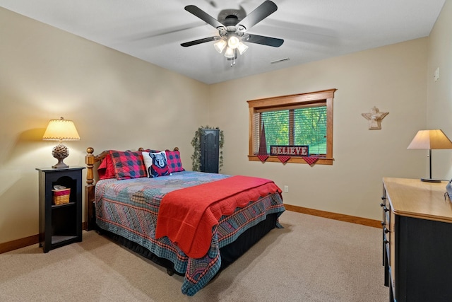 bedroom with light carpet, a ceiling fan, visible vents, and baseboards