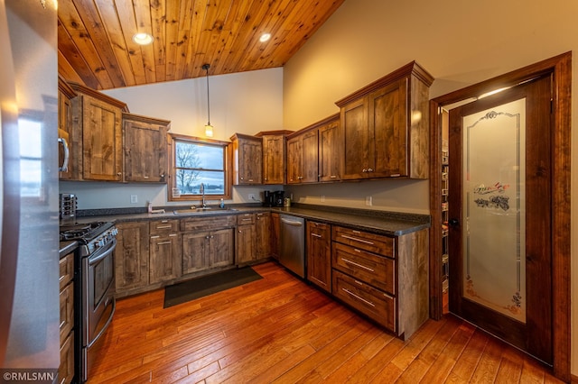 kitchen featuring stainless steel appliances, a sink, dark wood-style floors, recessed lighting, and wood ceiling