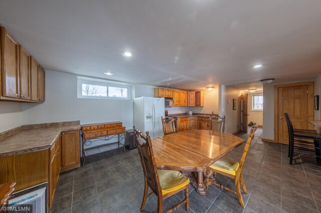 dining space featuring recessed lighting, dark tile patterned floors, and baseboards