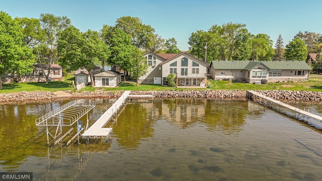dock area with a water view and a yard