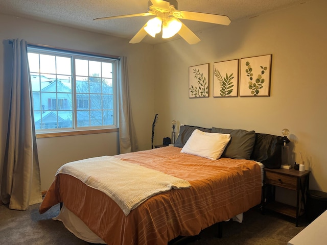 carpeted bedroom featuring ceiling fan and a textured ceiling