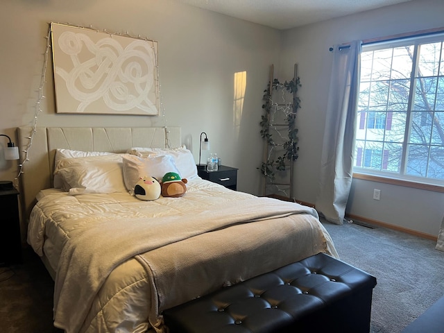 carpeted bedroom featuring multiple windows and baseboards