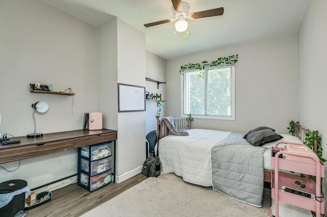 bedroom featuring ceiling fan, baseboards, and wood finished floors