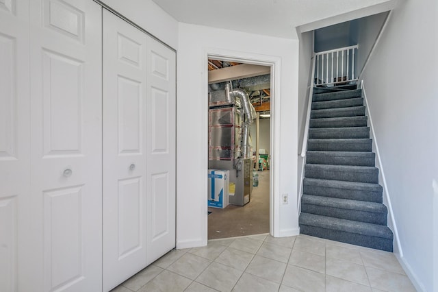 staircase with baseboards and tile patterned floors