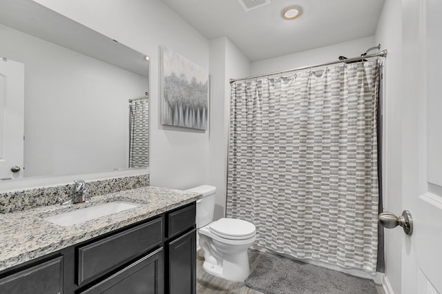 bathroom featuring toilet, visible vents, a shower with shower curtain, and vanity