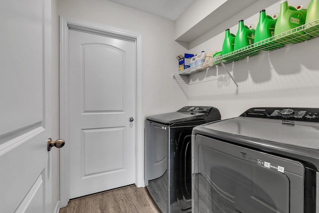 laundry room with laundry area, washer and dryer, and wood finished floors