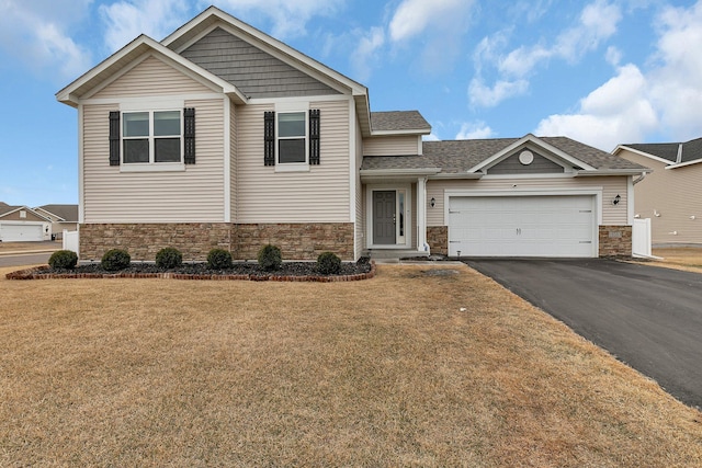 view of front of house with stone siding, aphalt driveway, a front lawn, and an attached garage