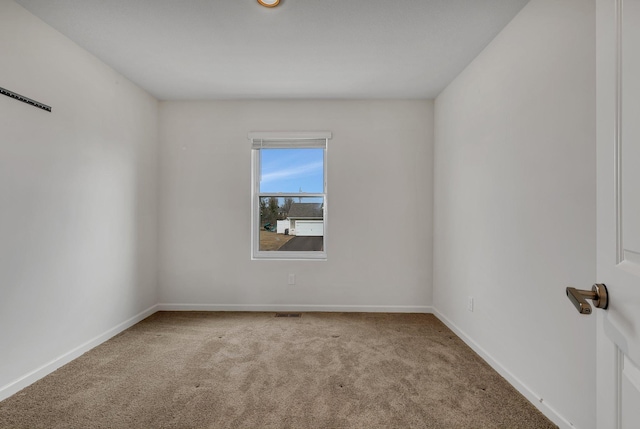 carpeted empty room with visible vents and baseboards