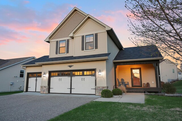 5108 Harvest Curv, Mayer, MN 55360 - view of front of home with a lawn, covered porch, stone siding, an attached garage, and driveway