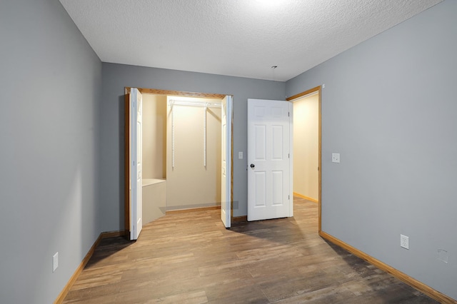 5108 Harvest Curv, Mayer, MN 55360 - unfurnished bedroom with baseboards, a textured ceiling, and wood finished floors