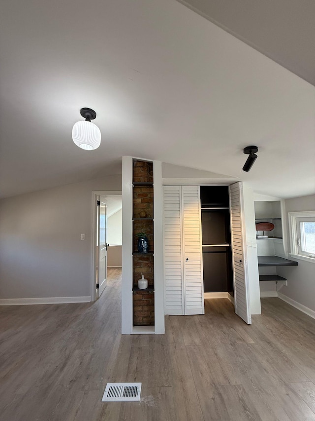 unfurnished bedroom featuring wood finished floors, visible vents, and baseboards