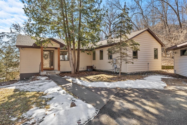 single story home with a shingled roof and central air condition unit