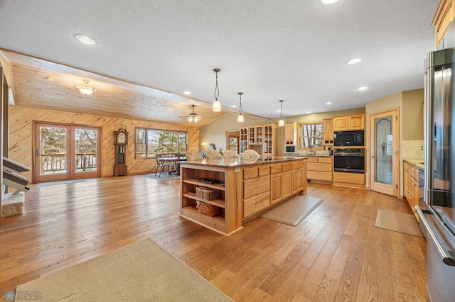 kitchen featuring black microwave, light brown cabinets, light wood-style flooring, oven, and open shelves