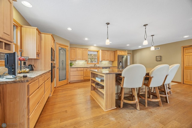 kitchen featuring open shelves, light wood-style floors, light brown cabinetry, black appliances, and a kitchen bar