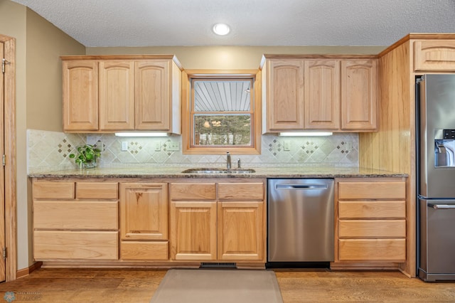 kitchen with a sink, appliances with stainless steel finishes, and light brown cabinets