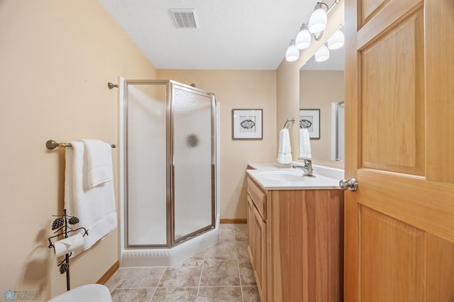 bathroom with visible vents, a shower stall, vanity, and a textured ceiling