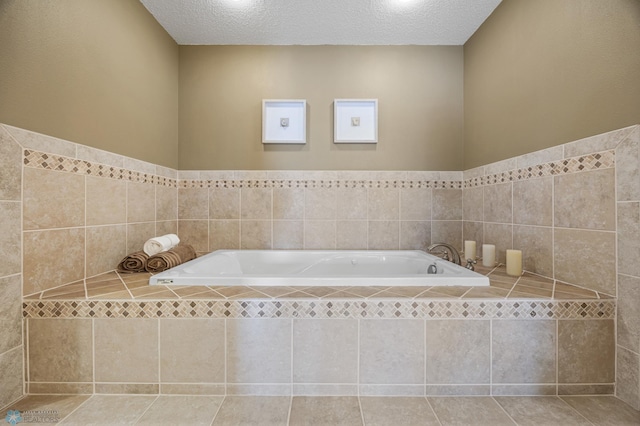 full bath featuring tile patterned flooring, a textured ceiling, and a bath