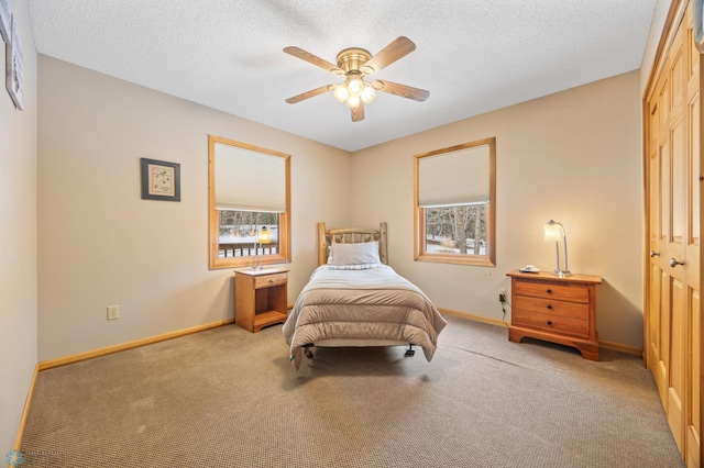 bedroom featuring a textured ceiling, carpet floors, a ceiling fan, and baseboards