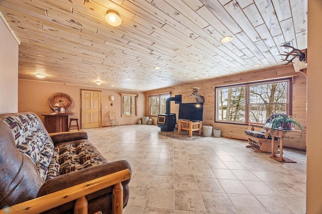 tiled living room with wood walls, wooden ceiling, and a wood stove