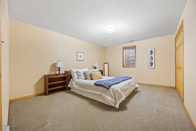 bedroom with light carpet, baseboards, and a textured ceiling