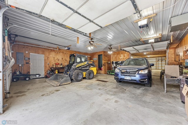 garage featuring metal wall, electric panel, and a garage door opener