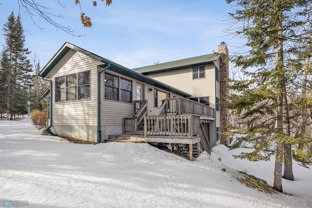 view of front of home with a chimney, stairway, and a wooden deck