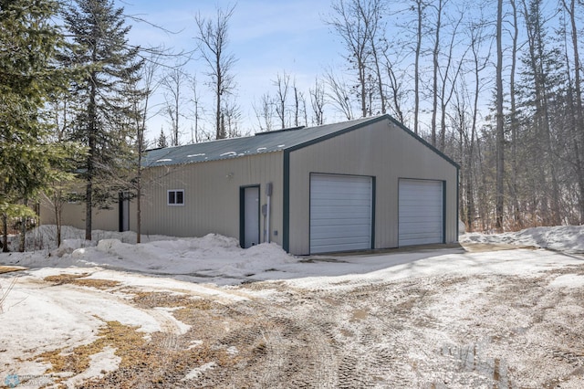 snow covered garage with a garage