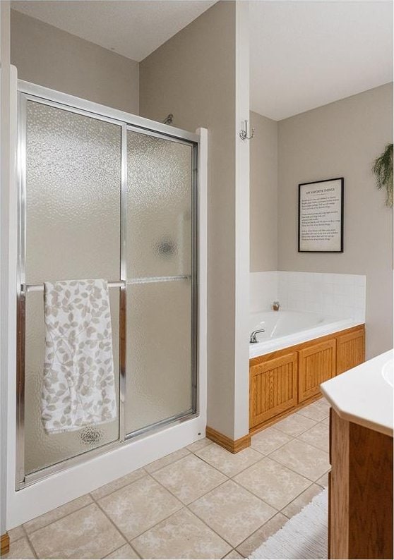 bathroom featuring a garden tub, a stall shower, and tile patterned flooring