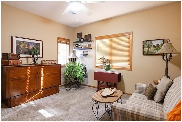 living area with carpet floors, baseboards, and a ceiling fan