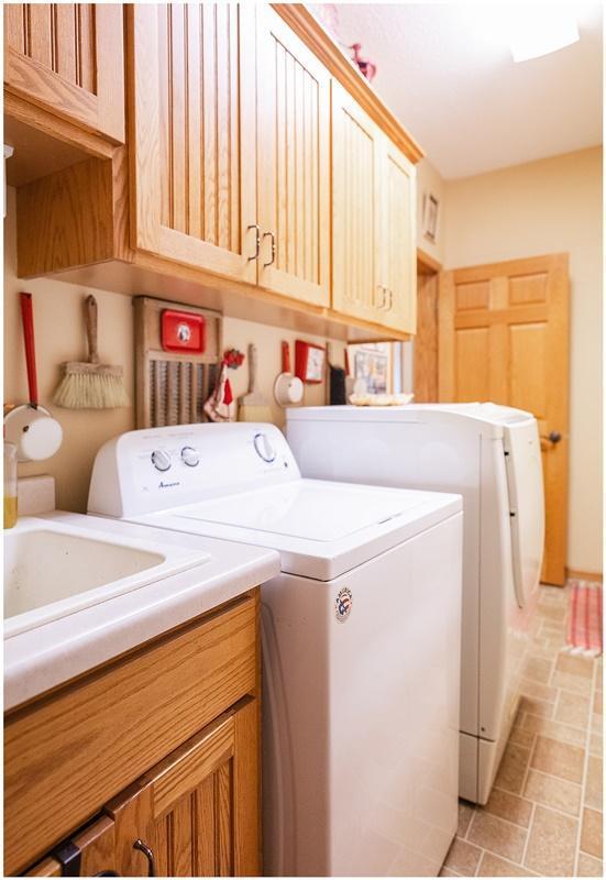 washroom with cabinet space, stone finish floor, and separate washer and dryer