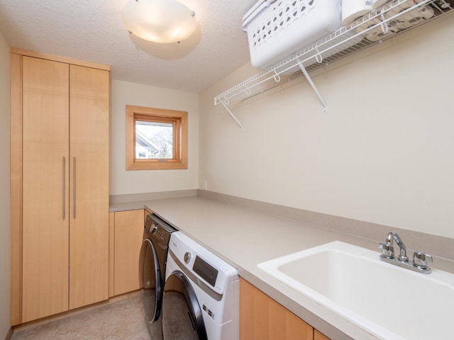 laundry room with cabinet space, light tile patterned floors, washing machine and clothes dryer, a textured ceiling, and a sink