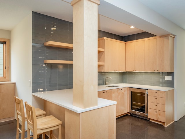 kitchen featuring wine cooler, open shelves, a sink, backsplash, and light brown cabinetry