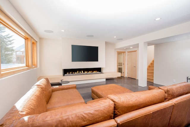 living room with recessed lighting, a lit fireplace, and stairs