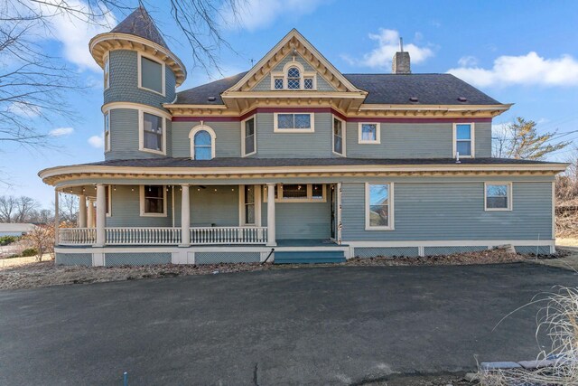 victorian home featuring covered porch and a chimney