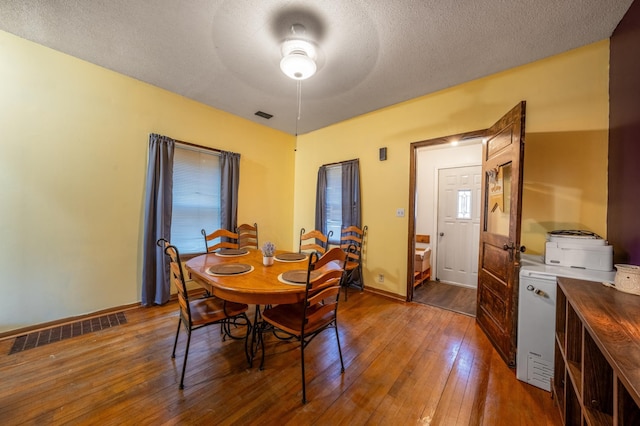 dining room featuring hardwood / wood-style flooring, baseboards, and visible vents