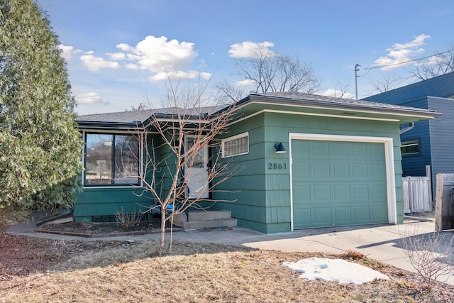 ranch-style house featuring an attached garage, fence, and driveway