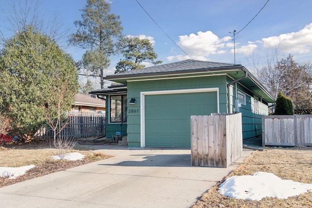 view of front of home featuring a garage, concrete driveway, and fence