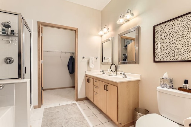 bathroom with a sink, toilet, a shower stall, and tile patterned flooring