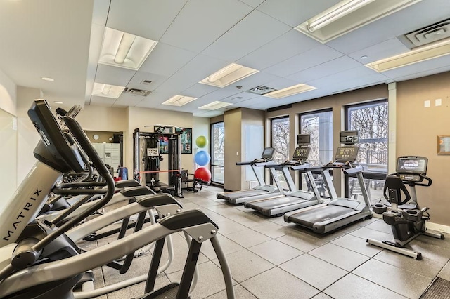 exercise room with a drop ceiling and visible vents