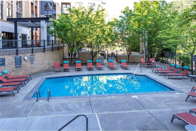 pool featuring a patio area and fence