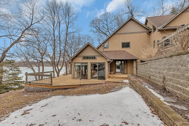 view of front of house featuring a shingled roof, a sunroom, and a deck