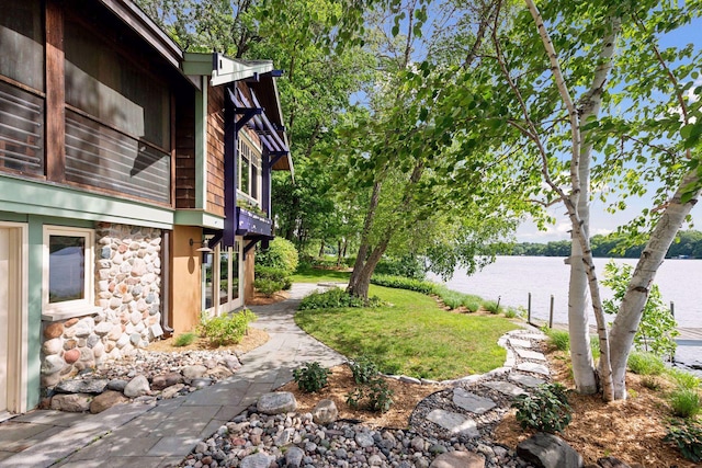 view of yard with french doors and a water view