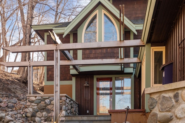 doorway to property featuring a shingled roof