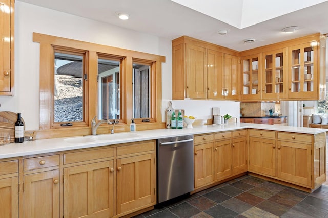 kitchen featuring a peninsula, a sink, light countertops, dishwasher, and glass insert cabinets