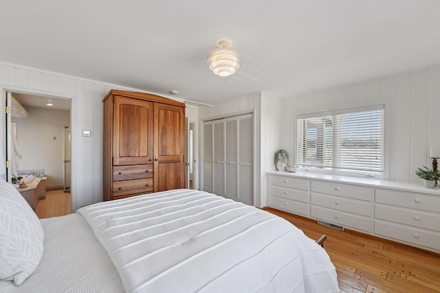 bedroom featuring a closet, visible vents, and light wood finished floors