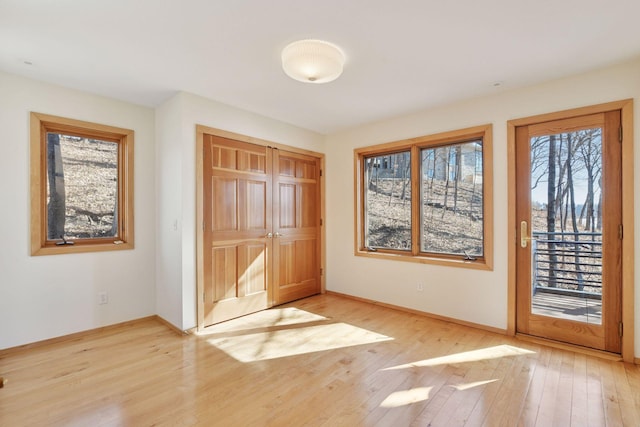 entryway with light wood finished floors and baseboards