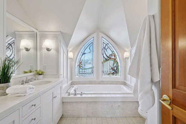 full bath featuring lofted ceiling, a garden tub, and vanity