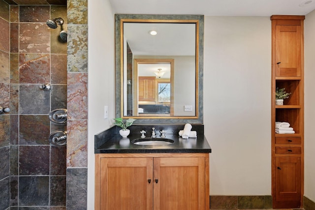 bathroom featuring a tile shower and vanity