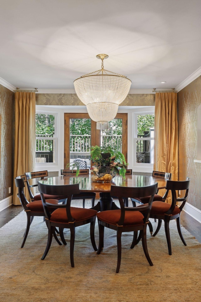 dining space featuring a chandelier, ornamental molding, wood finished floors, and a wealth of natural light